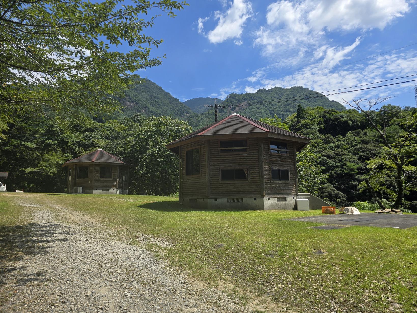 祝子川キャンプ場｜木立に佇むコテージと、川沿いのテントサイト-3